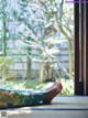 A person laying on a yoga mat in front of a window.