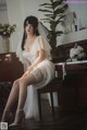 A woman in a wedding dress sitting on a piano.