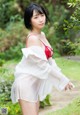 A woman in a white shirt and red bra posing for a picture.