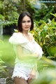 A woman in a white top and white shorts posing for a picture.