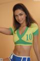 A woman in a green and yellow shirt and blue shorts.