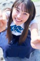 A young woman in a school uniform taking a selfie.