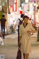 A woman walking down a city street at night.