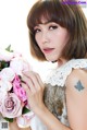 A woman holding a bouquet of pink roses in her hand.