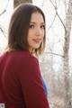 A woman in a red shirt is posing for a picture.